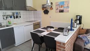a kitchen with a table and chairs in a kitchen at Huus Kompass - Familienurlaub mit Hund nahe am Nordseestrand in Butjadingen