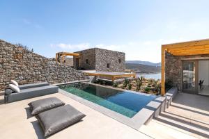 a villa with a swimming pool and a house at Panormos Bay Suites Luxury Resort in Mikonos