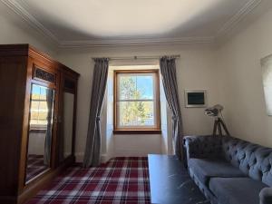a living room with a couch and a window at Loch Leven Hotel & Distillery in Glencoe