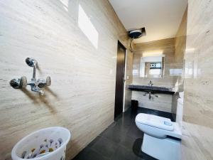 a bathroom with a white toilet and a sink at La Casa Residency in Lucknow