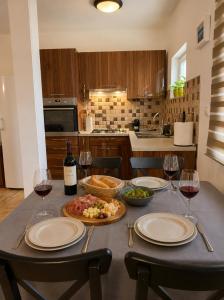 a table with plates of food and wine glasses at Apartment Near Zadar Airport & City in Crno