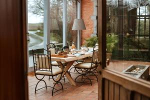 a porch with a table and chairs on a patio at Haras de Baudemont in Ittre