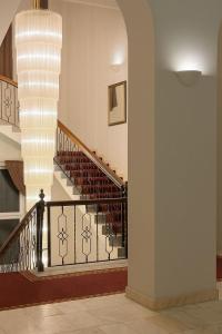 a hallway with a staircase with a chandelier at Vila Băncii 1888 by SunGarden in Băile Herculane +18 photos