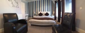 a bedroom with a bed and two chairs at The Waterford in Blackpool