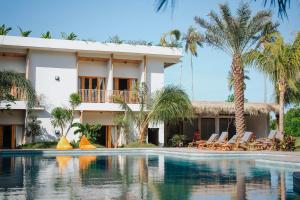 a resort with a swimming pool and palm trees at Giri Rose Boutique Hotel in Kuta Lombok