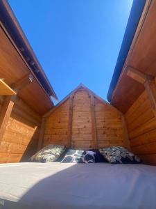 a bed in a wooden room with a roof at Altaluna tiny house sotto le stelle in Trebbiantico