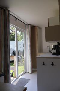 a kitchen with a sliding glass door to a patio at Mini-chalet - Vakantiepark 't Urkerbos in Urk