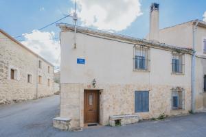 an old white building with a door in a street at Casa Romo 1 in Chavida