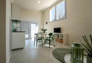a kitchen and living room with a table and chairs at Casa del Falegname - Loft Abete con cucina in San Giovanni in Bosco