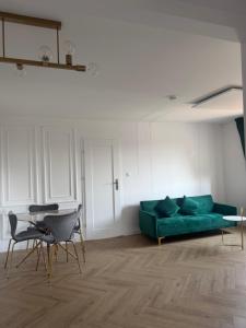 a living room with a green couch and chairs at Brickller Apartments by Letrent in Żyrardów