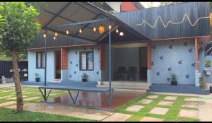 a house with a picnic table in front of it at Dewdrops Poolvilla in Meppādi