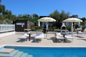 a patio with chairs and umbrellas next to a pool at Respiro di Tramonto in Montegranaro
