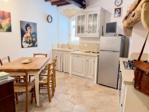 a kitchen with a table and a refrigerator at Casa Mariarosa in Volterra