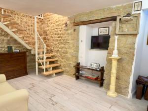 a living room with a staircase and a tv at Casa Mariarosa in Volterra