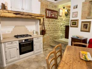 a kitchen with a stove and a wooden table at Casa Mariarosa in Volterra +4 photos