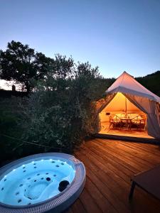 a tent with a hot tub on a wooden deck at Stecadó Glamping in Dolceacqua +33 photos