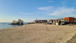 an empty beach with a volleyball net in the sand at Mini-chalet - Vakantiepark 't Urkerbos in Urk