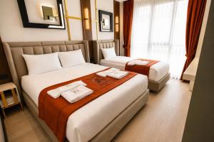a hotel room with two beds with towels on them at Nearest Airport Hotel in Arnavutköy