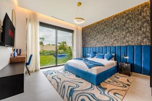 a bedroom with a blue bed and a large window at Villa Gaspard - Piscine et jardin Privée Sans vis-à-vis Wifi HD in Marrakesh