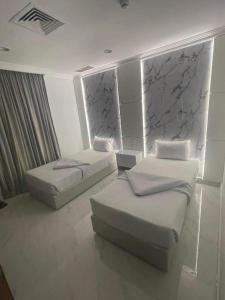 two twin beds in a room with at Continental Hotel & Suite in Kuwait