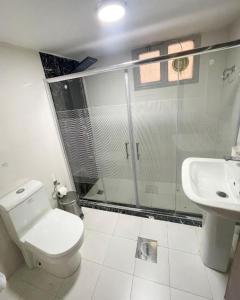 a bathroom with a shower and a toilet and a sink at Continental Hotel & Suite in Kuwait