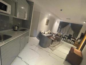 a kitchen and living room with a couch and a table at Continental Hotel & Suite in Kuwait