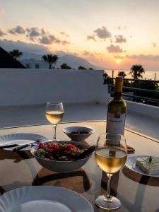 a table with a bowl of food and a bottle of wine at Amalia Apartments in Polis Chrysochous