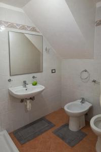 a bathroom with a sink and a toilet and a mirror at Barrique in Villa Viani
