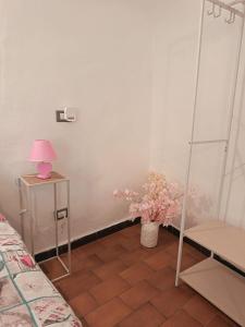 a room with a table with a lamp and a vase of flowers at Barrique in Villa Viani