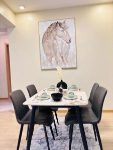 a dining room table with a painting of a horse at Two-Bedroom Apartment Near JKIA & SGR Free Parking & Wi-Fi By Irene in Nairobi +5 photos
