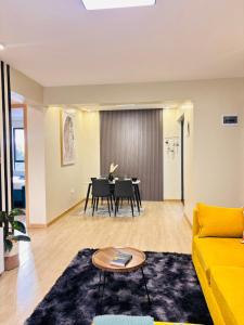 a living room with a yellow couch and a table at Two-Bedroom Apartment Near JKIA & SGR Free Parking & Wi-Fi By Irene in Nairobi