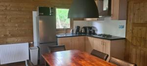 a kitchen with a wooden table and a table and chairs at Vakantiepark 't Urkerbos - 4 persoons Brabantse blokhut in Urk