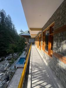 a balcony of a house with a swimming pool at The Zoland in Jibhi
