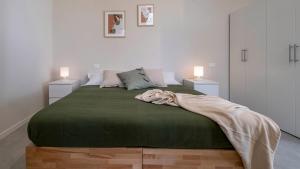 a bedroom with a green bed with two night stands at Casa del Falegname - Loft Abete con cucina in San Giovanni in Bosco