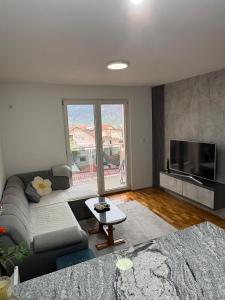 a living room with a couch and a flat screen tv at FocaLux in Foča +1 photo