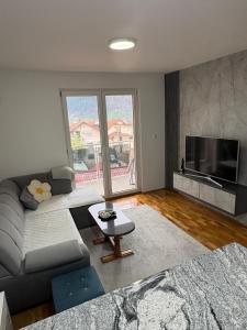a living room with a couch and a tv at FocaLux in Foča