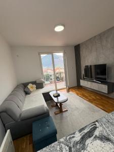 a living room with a couch and a tv at FocaLux in Foča
