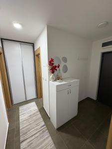 a room with a white cabinet with flowers on it at FocaLux in Foča