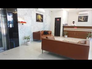 a waiting room with two couches and a reception desk at Kanakplace in Indore