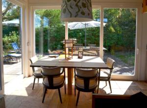 a dining room table with chairs and a large window at Vakantiewoning MV8 in Egmond-Binnen