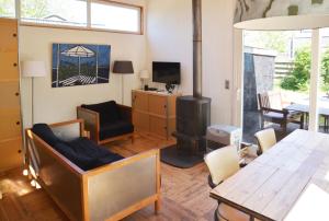 a living room with a wood stove and a table at Vakantiewoning MV8 in Egmond-Binnen