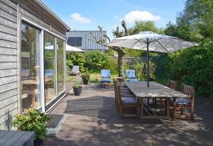 a table and chairs with an umbrella on a patio at Vakantiewoning MV8 in Egmond-Binnen