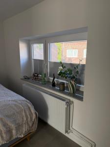 a bedroom with a bed and a window with flowers at Stillvolle Apartment NV in Neukirchen-Vluyn