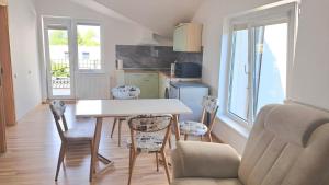 a kitchen and dining room with a table and chairs at Vila Uosis in Palanga