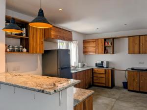a kitchen with wooden cabinets and a stainless steel refrigerator at Seth Villa Matara in Matara