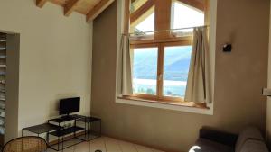 a living room with a window and a couch at Chalet al Lac - Cuori - Swimming Pool Como Lake View in Consiglio di Rumo