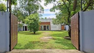 an open gate to a house with a yard at Seth Villa Matara in Matara
