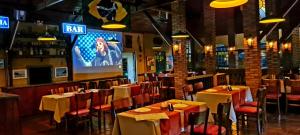 a restaurant with tables and chairs and a bar at Pousada Catuaí in Siqueira Campos