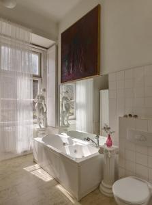 a white bathroom with a tub and a toilet at Schloss Hollenburg Aparte Apartments in Krems an der Donau +61 photos