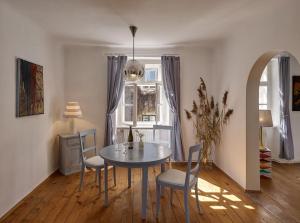 a dining room with a table and chairs and a window at Schloss Hollenburg Aparte Apartments in Krems an der Donau